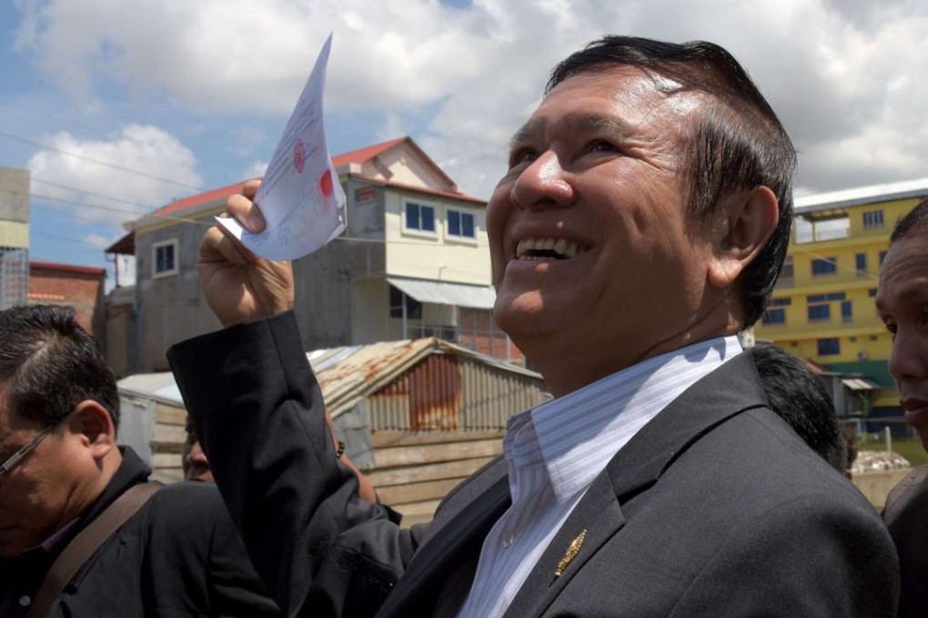 Kem Sokha, Cambodia's opposition party deputy leader, shows his voter documents after registering for local 2017 elections in Phnom Penh. Photo: AFP