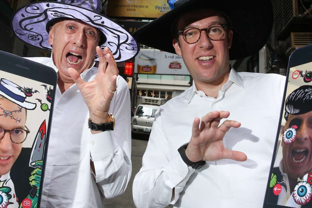 Allan Zeman (left) and Jonathan Zeman show off their new app as they get into the Halloween spirit in Lan Kwai Fong. Sam Tsang