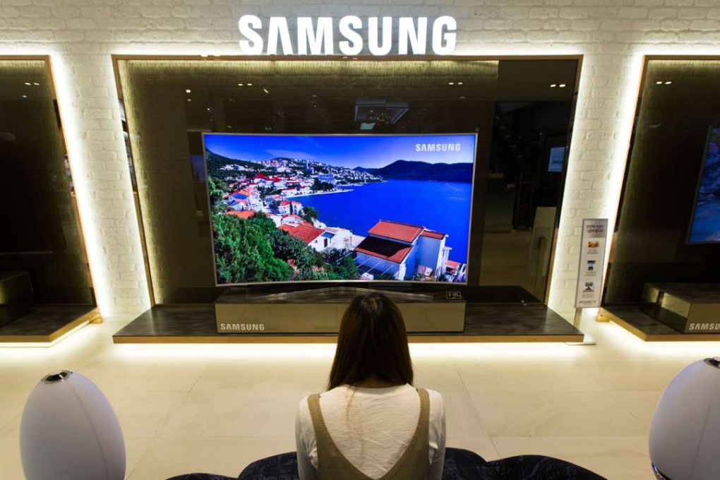 A visitor watches a Samsung Electronics Co. curved SUHD television at the company's D'light flagship store in Seoul, South Korea. Photo: Bloomberg