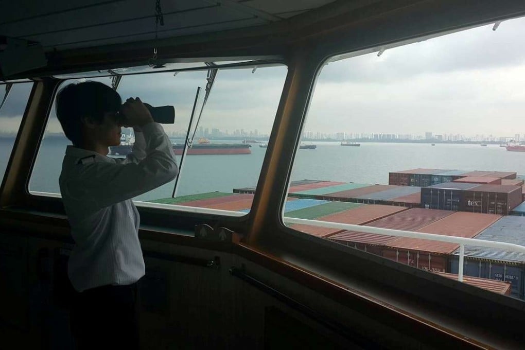 A crew member looks out from the deck of a ship in Singapore. Photo: Reuters