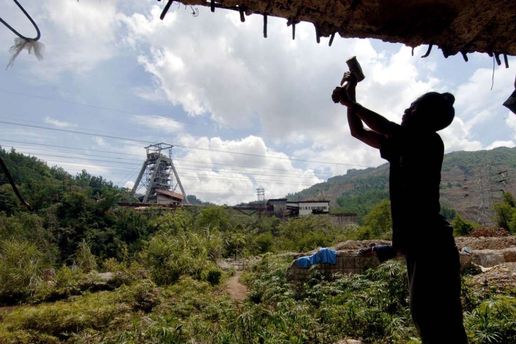 A laid off worker of Atlas Consolidated Mining and Development Corp. salvages materials at the crumbling buildings of the company's shuttered Carmen copper mine on the outskirts of Toledo city. Photo: AFP