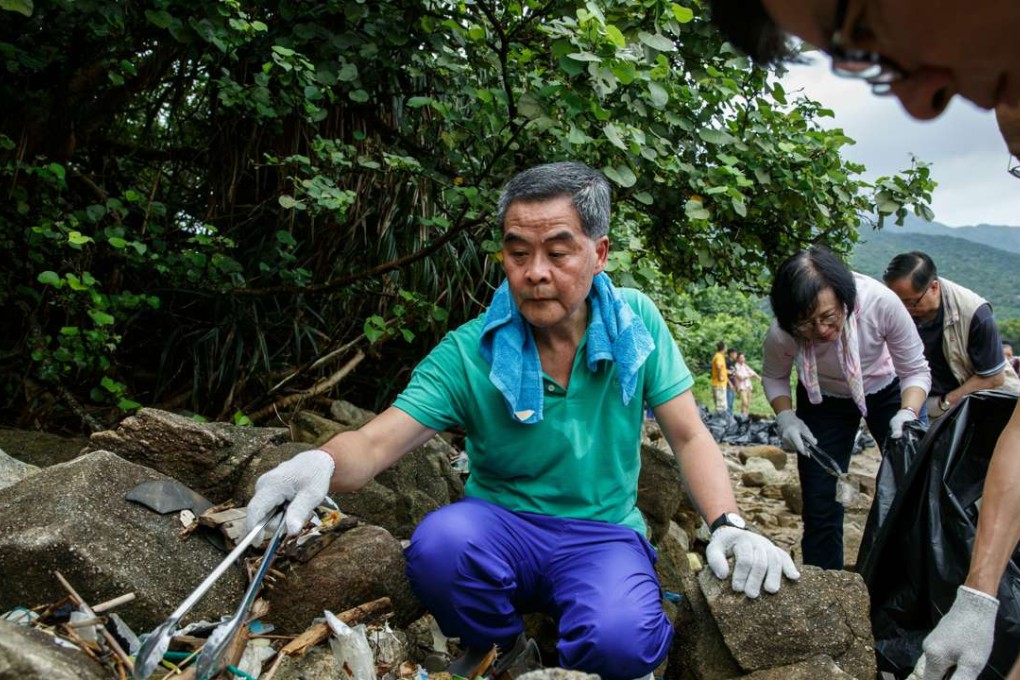 Hong Kong’s Chief Executive Leung Chun-ying helps to pick up refuse washed ashore at the top of a beach in Hong Kong in July. Photo: AFP