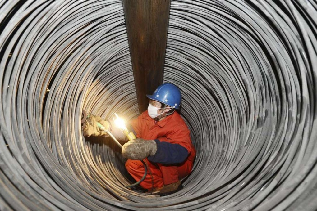 A worker checks steel rods at a plant of Dongbei Special Steel Group in Dalian, Liaoning province. The group has formally entered into a bankruptcy restructuring process. Photo: ImagineChina