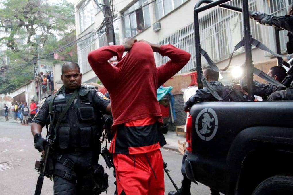 A police officer arrests a suspected drug dealer after a shootout during a police operation at Pavao-Pavaozinho slum in Rio de Janeiro on Monday. Photo: Reuters