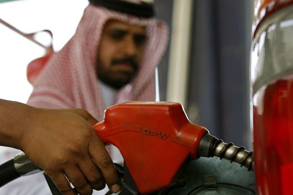 A Saudi man looks at an employee filling the tank of his car with petrol at a station in Jeddah. Photo: AAFP