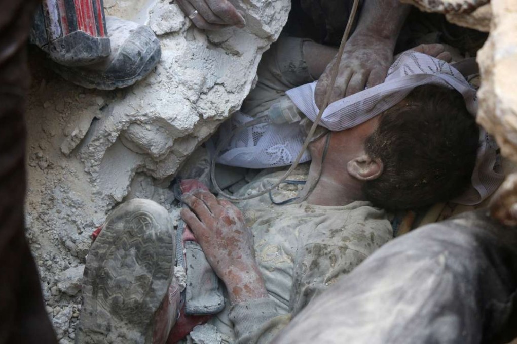 Jameel Mustafa Habboush, a young Syrian boy receives oxygen as he is pulled alive from the rubble of a building following Russian air strikes on the rebel-held Fardous neighbourhood of Aleppo on Tuesday. Photo: AFP