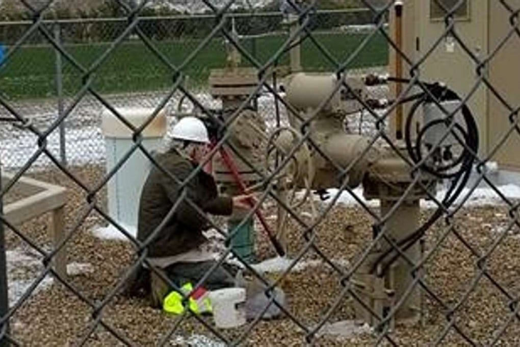 Climate-change activist Leonard Higgins turns off the flow of oil from a site targeted on Tuesday. Photo: Facebook/Leonard Higgins