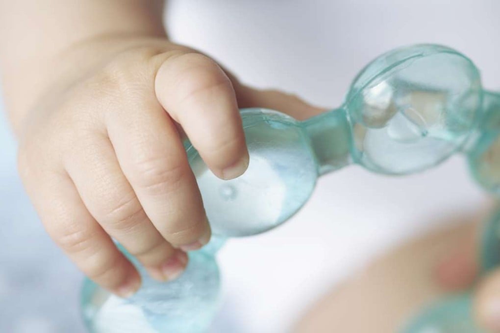 A baby holds a teething ring. The US FDA does not recommend any medicinal products for teething pain, and has linked homeopathic teething pain remedies to infant deaths . Photo: Corbis