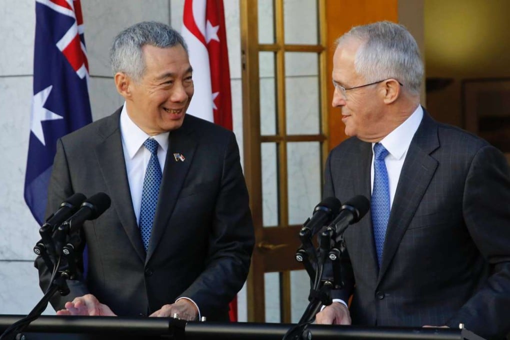 Singapore's Prime Minister Lee Hsien Loong (L) speaks with his Australian counterpart Malcolm Turnbull during a joint press conference at Parliament House in Canberra on October 13, 2016. Australia and Singapore pledged deeper military collaboration while stressing the need for stability and order in Asia as tensions simmer between China and the United States. / AFP PHOTO / SEAN DAVEY