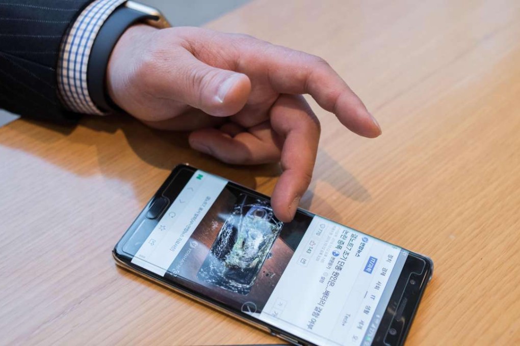 A customer browses a web page showing a fire-damaged Samsung Note 7 mobile phone, on a similar device, at a Samsung store. Photo: AFP