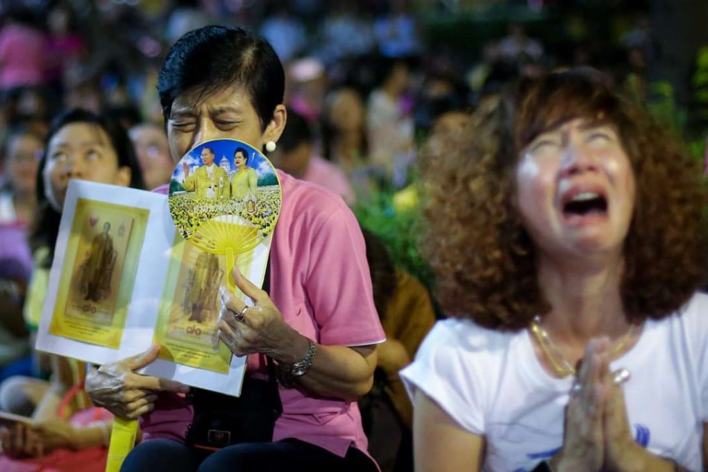 Thai women holding pictures of Thai King Bhumibol Adulyadej cry and mourn as they hear the news of His Majesty's death outside Siriraj Hospital in Bangkok, Thailand. Photo: EPA