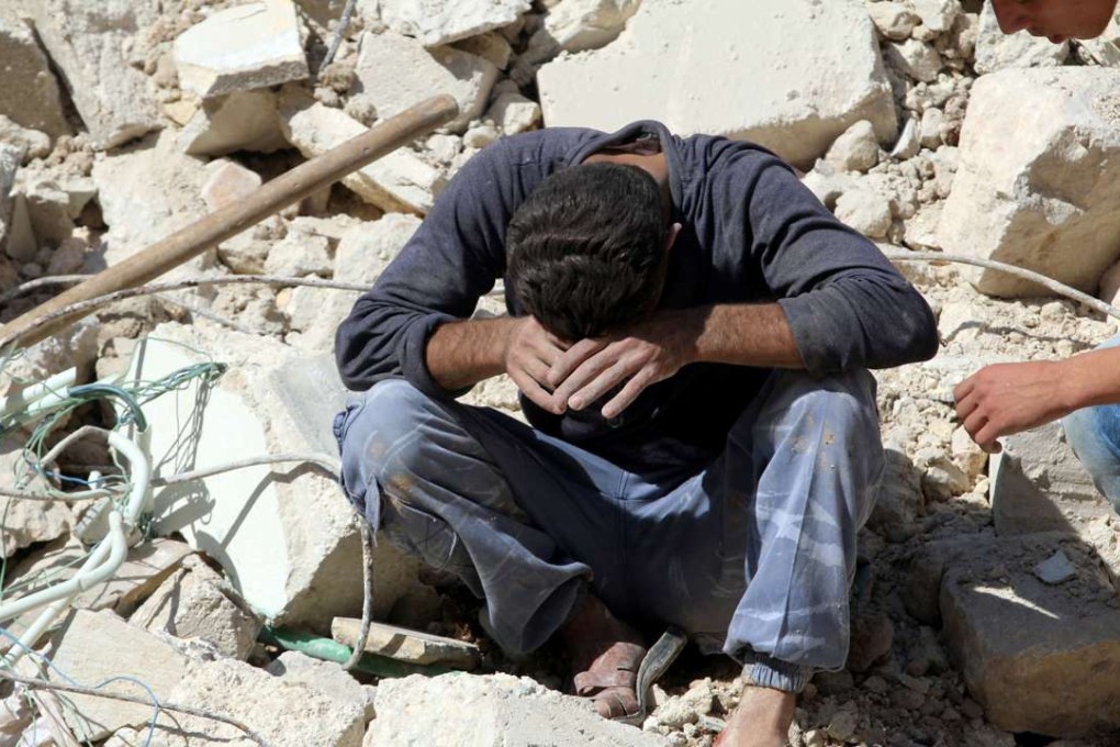 A man weeps over the deaths of relatives in an airstrike in the besieged rebel-held al-Qaterji neighbourhood of Aleppo, Syria, on Tuesday. Photo: Reuters