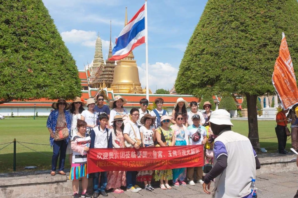 Chinese tourists pose for a group photo in front of the Grand Palace in Bangkok. Photo: SCMP Pictures