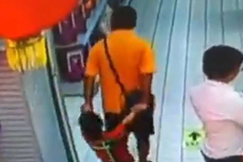 Surveillance footage shows the man falling backwards onto his son. Photo: SCMP Pictures