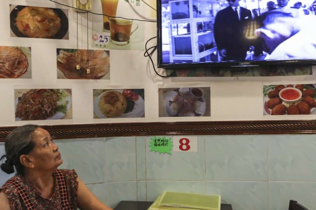 Jantharuechai Sommai, owner of Thai-E-San Ram Mis, a Thai restaurant in Kowloon City, watches news of the king’s death on TV. Photo: Bruce Yan