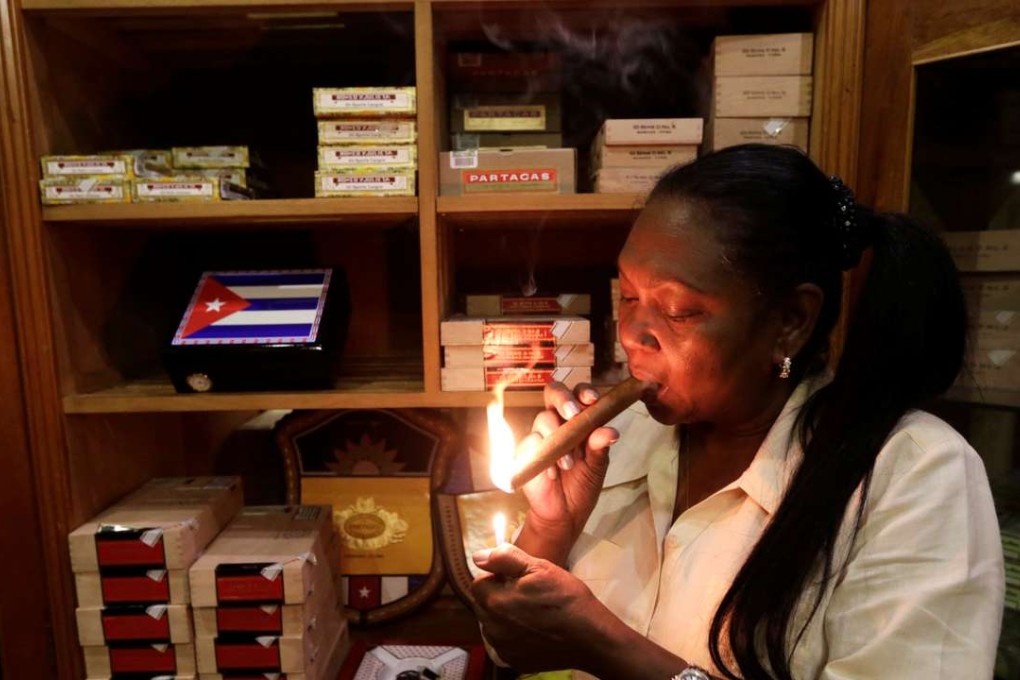 Staff member Juanita, 62, smokes a hand-rolled cigar at a hotel in Havana, Cuba. Photo: Reuters