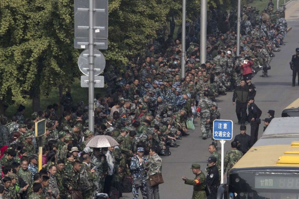 Chinese People’s Liberation Army veterans, many dressed in military fatigues, gather outside China’s Ministry of Defence to protest over pensions in Beijing on October 11. Photo: AP