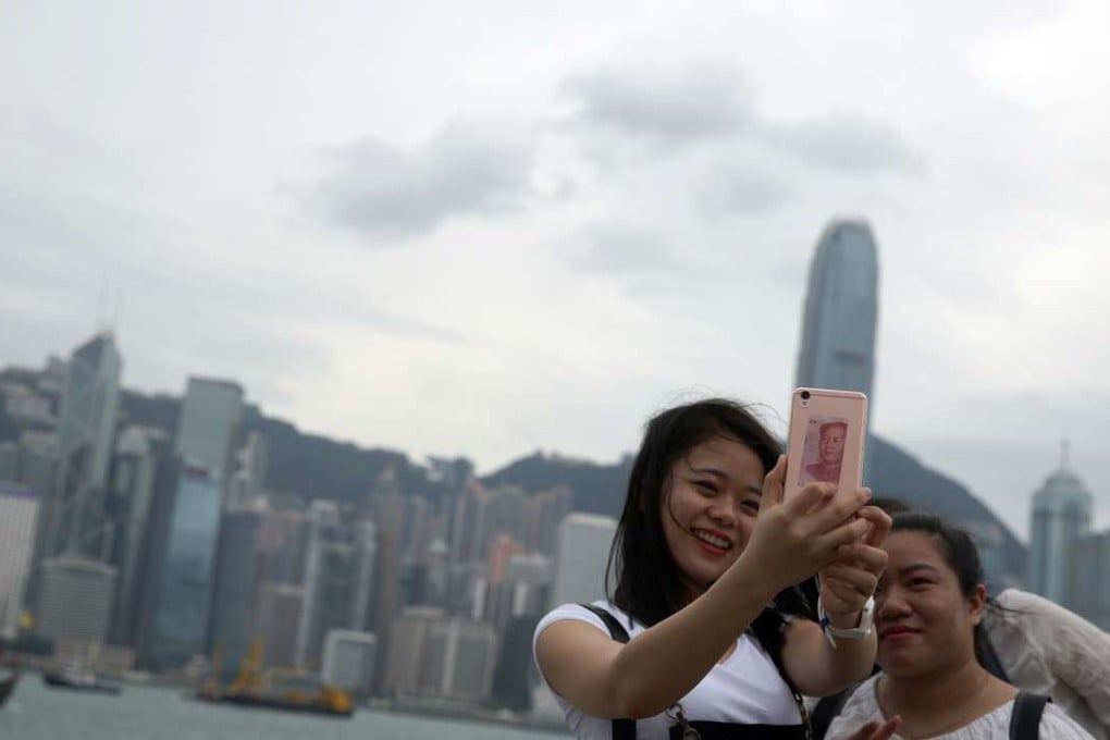 Tourists taking a selfie at the Tsim Sha Tsui waterfront as Typhoon Sarika draws closer to the city. Photo: Sam Tsang