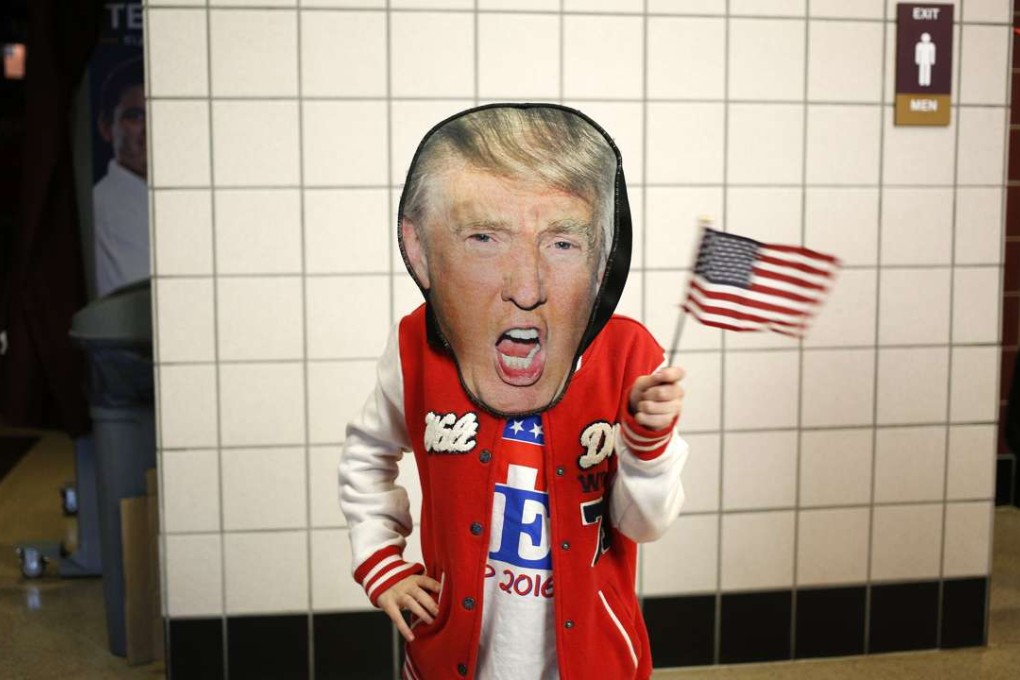 A young supporter wearing a Donald Trump mask poses before a campaign event for the Republican presidential nominee. The American political process has been reduced to sound bites filled with idiocy, insults, superficiality and non sequiturs. Photo: Bloomberg