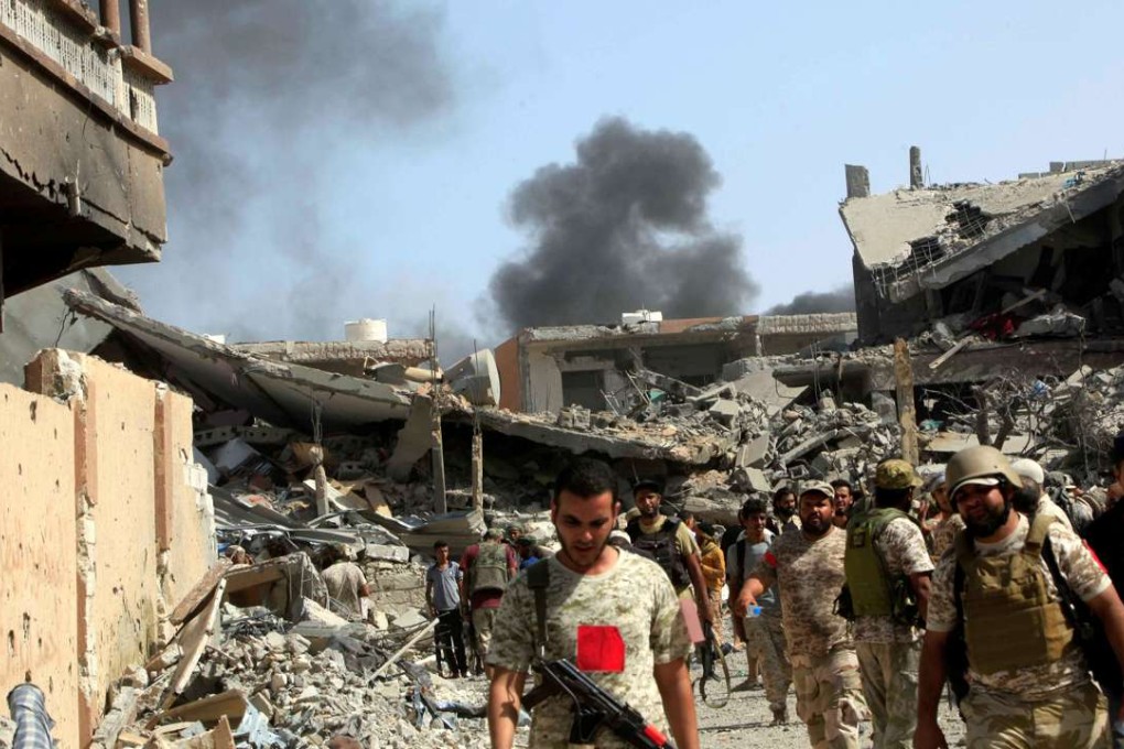 Smoke rises following an air strike as Libyan forces allied with the UN-backed government gather in Sirte, Libya, on Sunday. Photo: Reuters