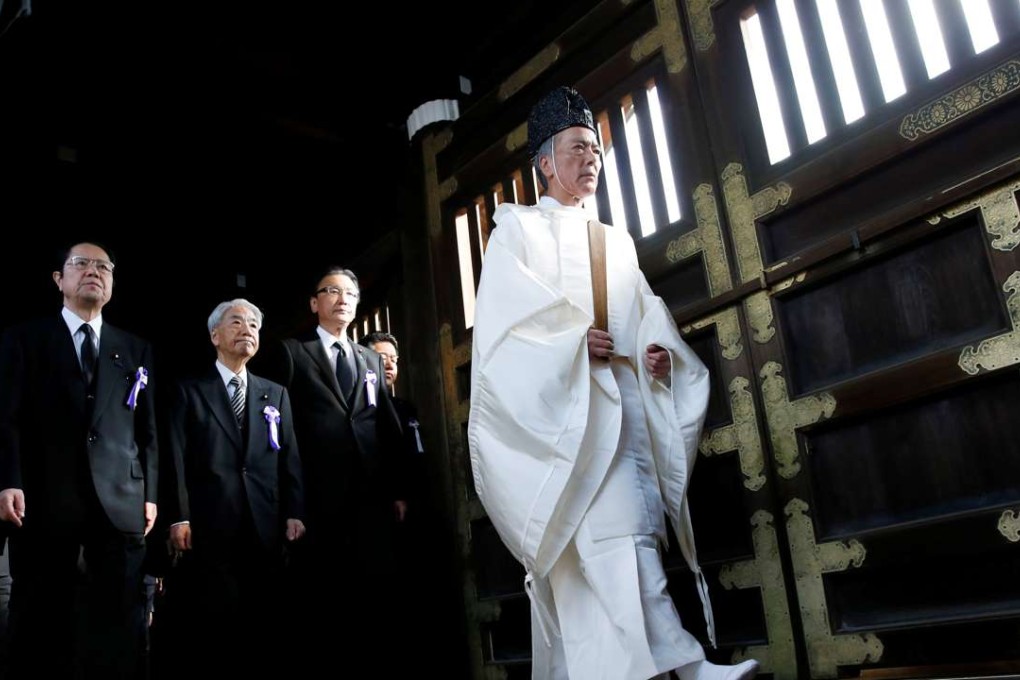 A group of lawmakers are led by a Shinto priest as they pay their respects at the Yasukuni Shrine in Tokyo. Photo: Reuters