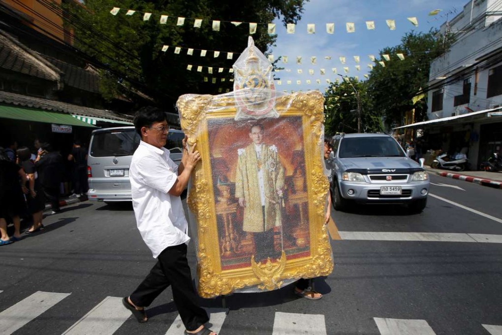 A man carrying a portrait of King Bhumibol Adulyadej. Photo: Reuters