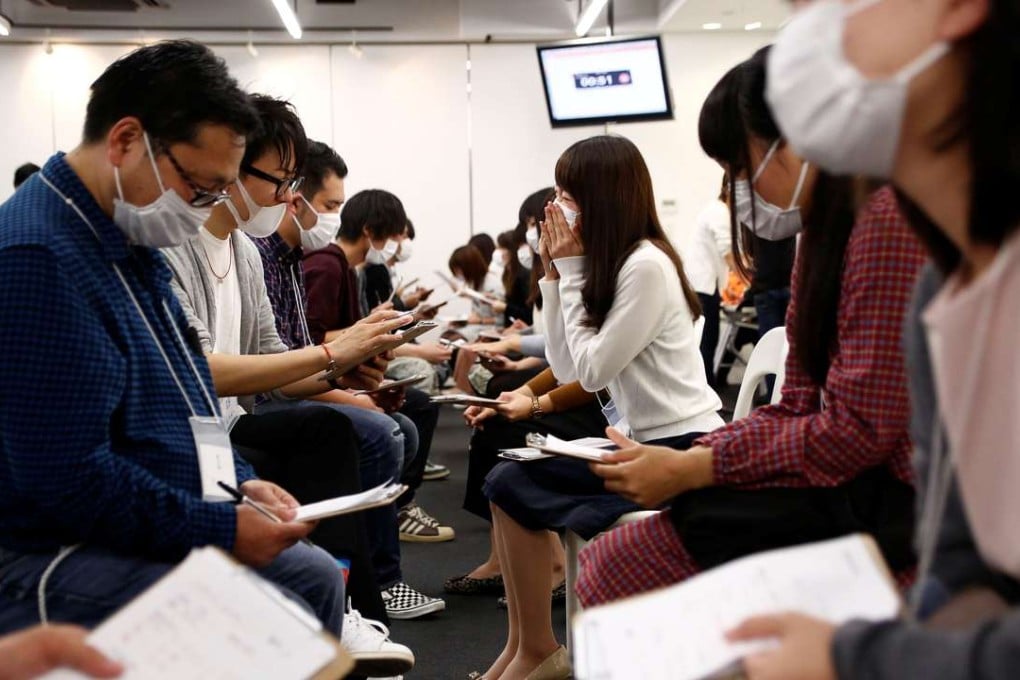 Participants wearing surgical masks talk to each other during a masked match-making event in Tokyo, Japan. Photo: Reuters