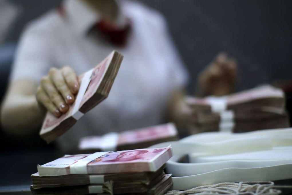 A file picture of a bank worker counting cash at a branch in Shanghai. Photo: Reuters