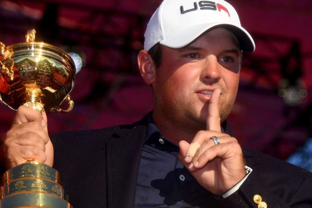 Patrick Reed of the United States gestures to the crowd while holding the Ryder Cup. Photo: AFP