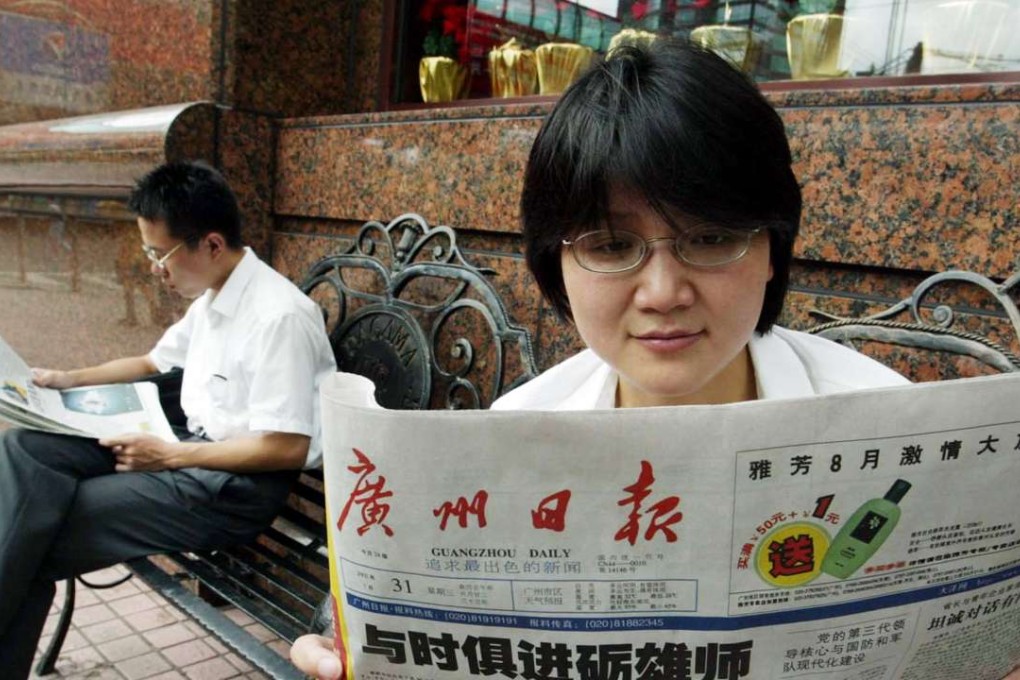 A file picture of a woman reading the Guangzhou Daily on the street. Photo: SCMP Pictures