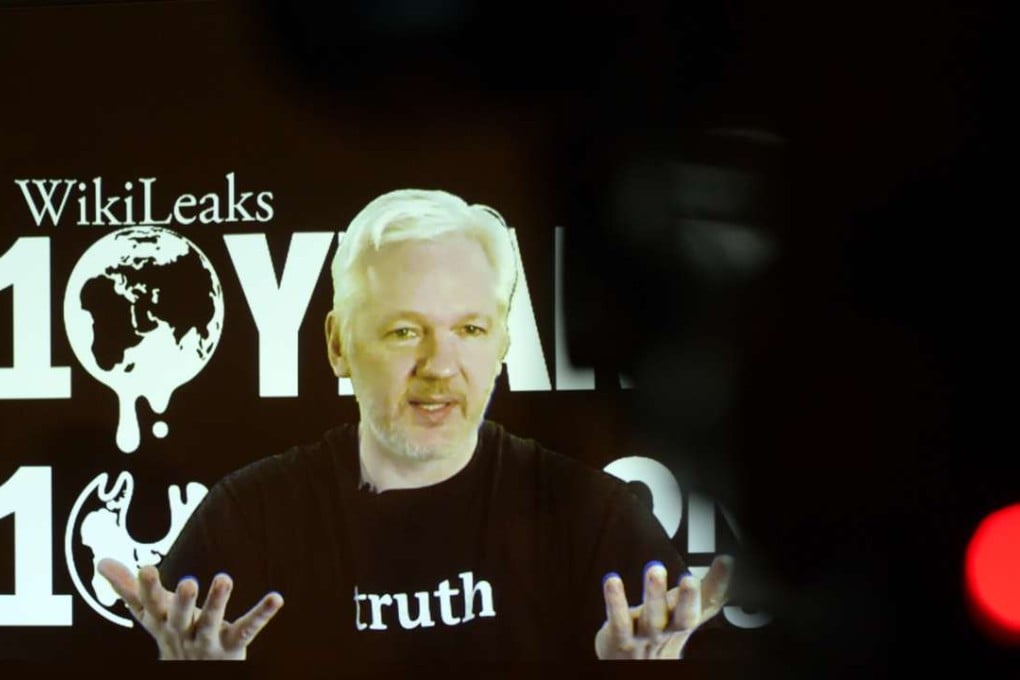 WikiLeaks founder Julian Assange speaks via video link at an event in Berlin on October 4. Assange says a company with Clinton ties is attempting to smear him. Photo: TNS