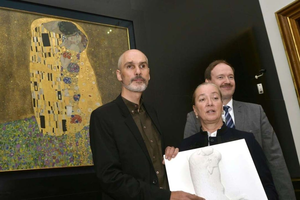 From left: Reiner Delgado (Blind Association), Belvedere museum manager Agnes Husslein-Arco and Christian Helmenstein (GF Economica) with the tactile graphic of Gustav Klimt’s ‘Kiss’ in front of the original artwork. Photo: AFP