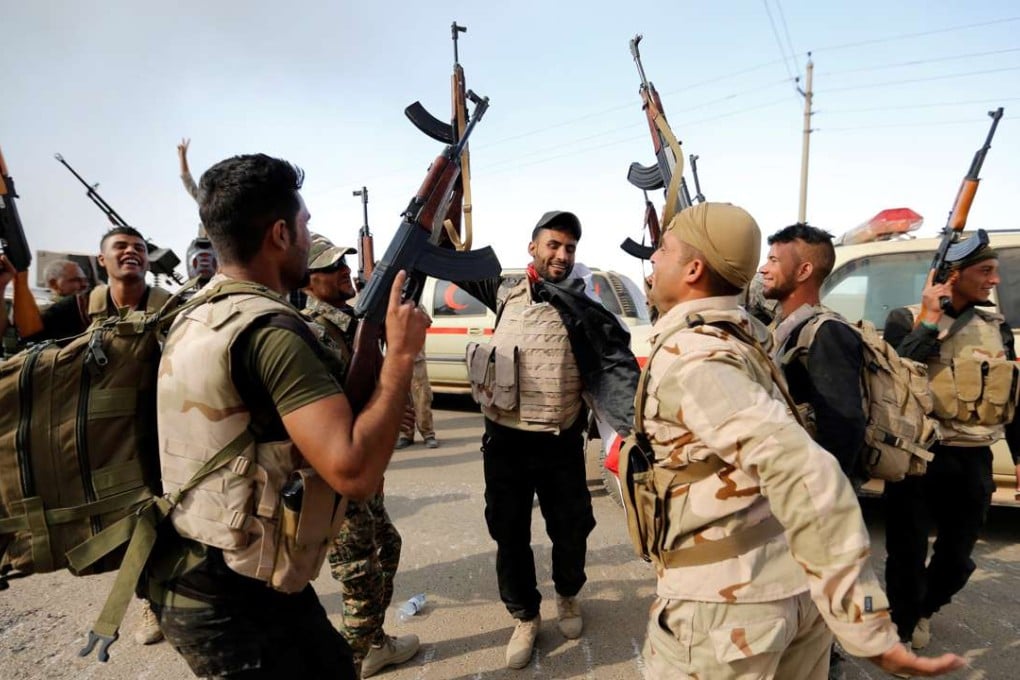 Members of Iraqi security forces celebrate after the liberation of Khalidiya village from Islamic State militants, south of Mosul, on Thursday. Photo: Reuters