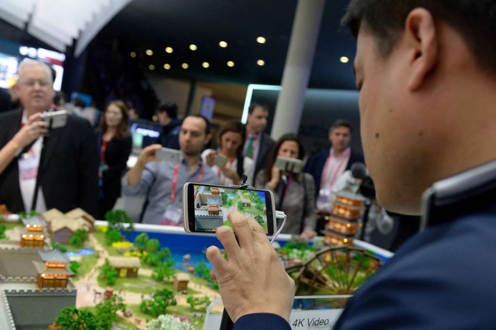 Visitors test models of the ZTE smartphones with 4K video at the Mobile World Congress in Barcelona. Photo: AFP