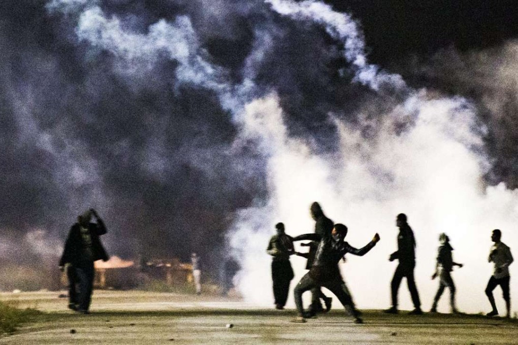 Asylum seekers clash with French riot police at the “Jungle” camp in Calais. Photo: EPA