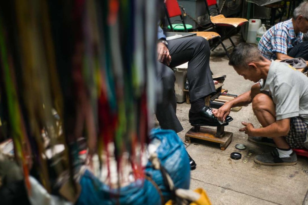 Shoeshiners at work in Hong Kong. Tradesmen who provide repairs for shoes and other items can still be found in Hong Kong but are becoming rare. Photo: AFP