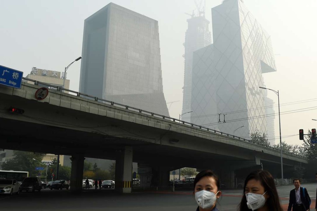 People wear masks on a street in Beijing earlier this month. More than five million air purifiers are expected to be sold in mainland China in 2016. Photo: Xinhua