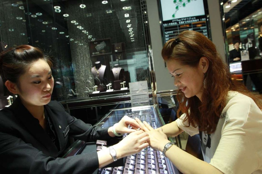 A customer tries on rings at a Luk Fook outlet in Shenzhen. 15APR11