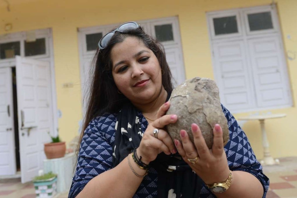 "Dinosaur Princess" Aaliya Sultana Babi holds a fossilised dinosaur egg at her palace in Balasinor. The rescued egg now has pride of place among her collection of prehistoric fossils, part of a lifelong legacy of protecting the dinosaur remains on the land her family once ruled over. Photo: AFP