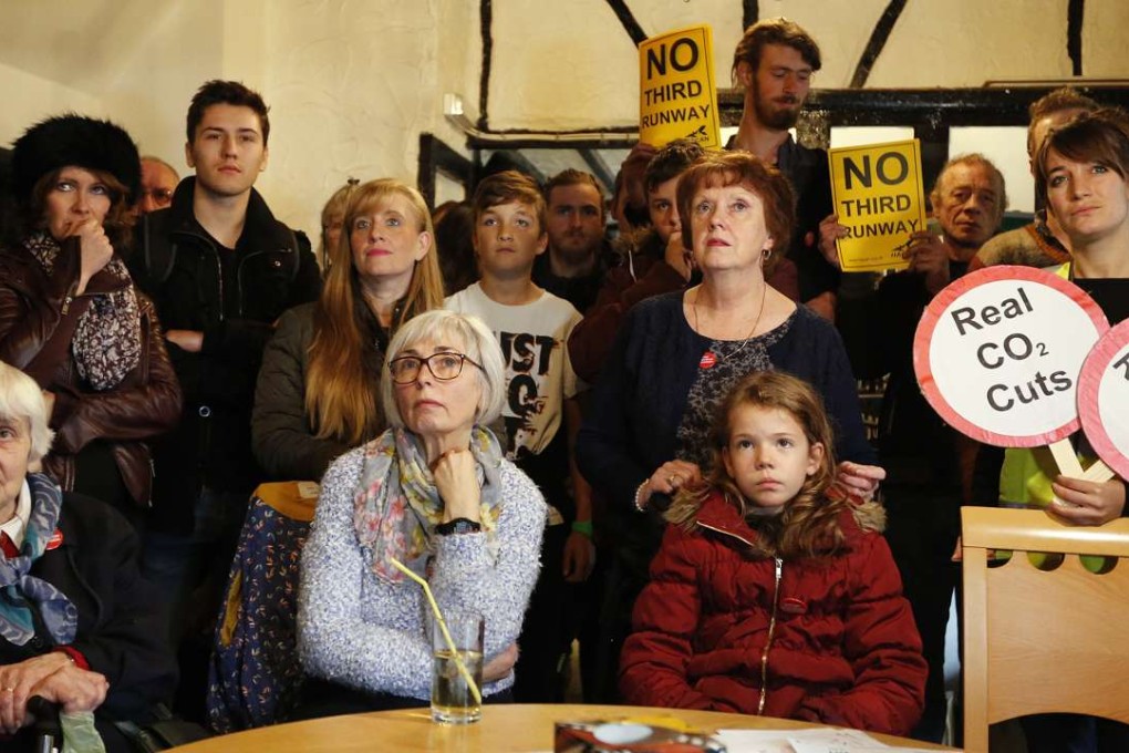 Residents of Harmondsworth gather in a pub listen to the decision on Tuesday to build a third runway for Heathrow Airport, effectively sentencing the village to demolition. Photo: AP