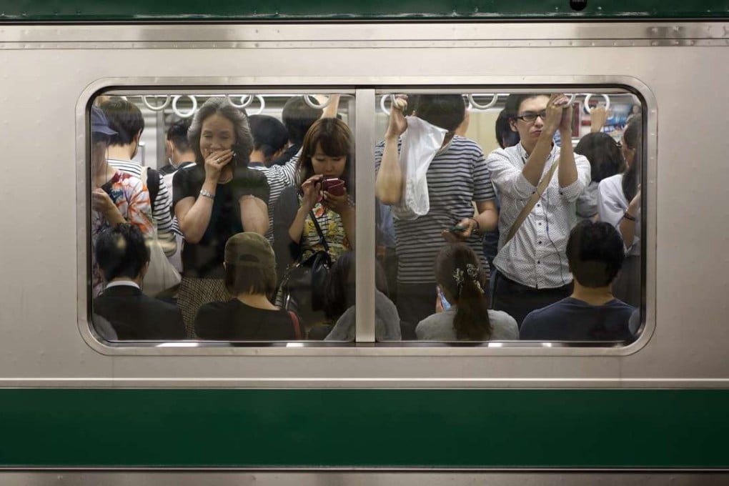 Commuters are stranded in a train at Ikebukuro station. Photo: EPA