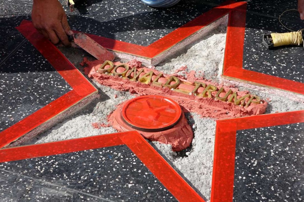 A worker repairs US Republican Presidential candidate Donald Trump's star on the Hollywood Walk of Fame after it was destroyed iby a vandal with a sledgehammer. Photo: EPA