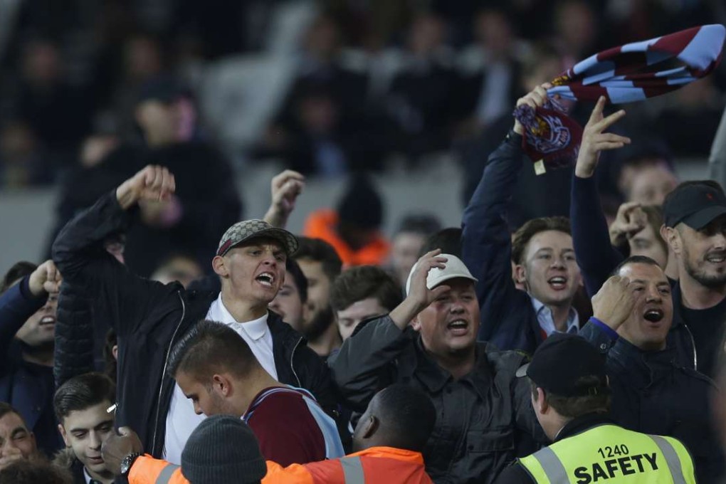 Rival supporters separated by stewards shout and gesture at each other during the EFL Cup match between West Ham United and Chelsea at the London Stadium. Photo: AP