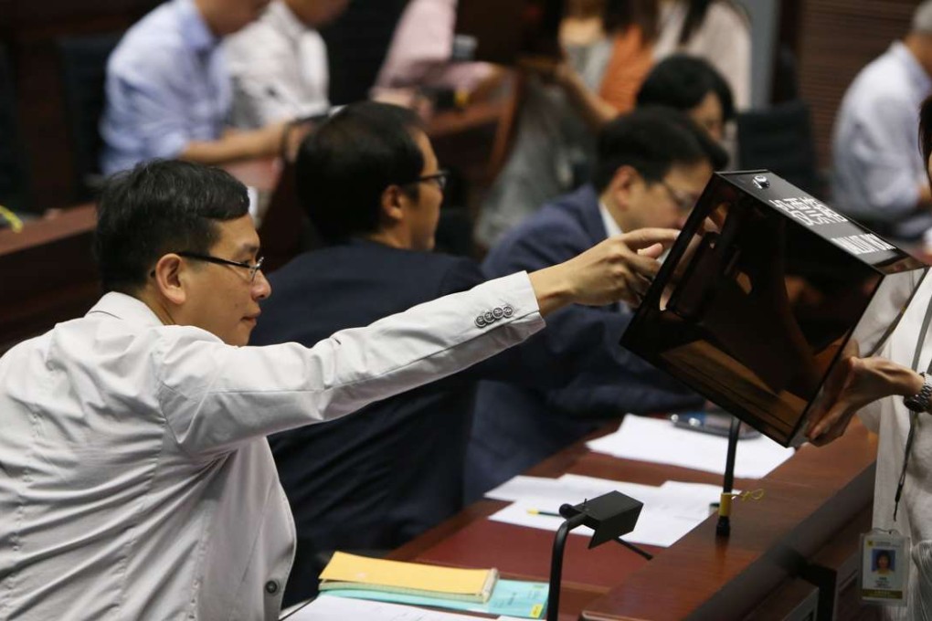 Legislator Ip Kin-yuen (left) casts a vote at the Legislative Council panel meeting. He was elected deputy chairman of the education panel. Photo: Dickson Lee