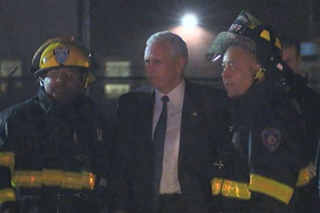 Republican presidential candidate Mike Pence with firefighters at New York's LaGuardia Airport after his campaign plane slid off the runway while landing on Thursday. Photo: AP
