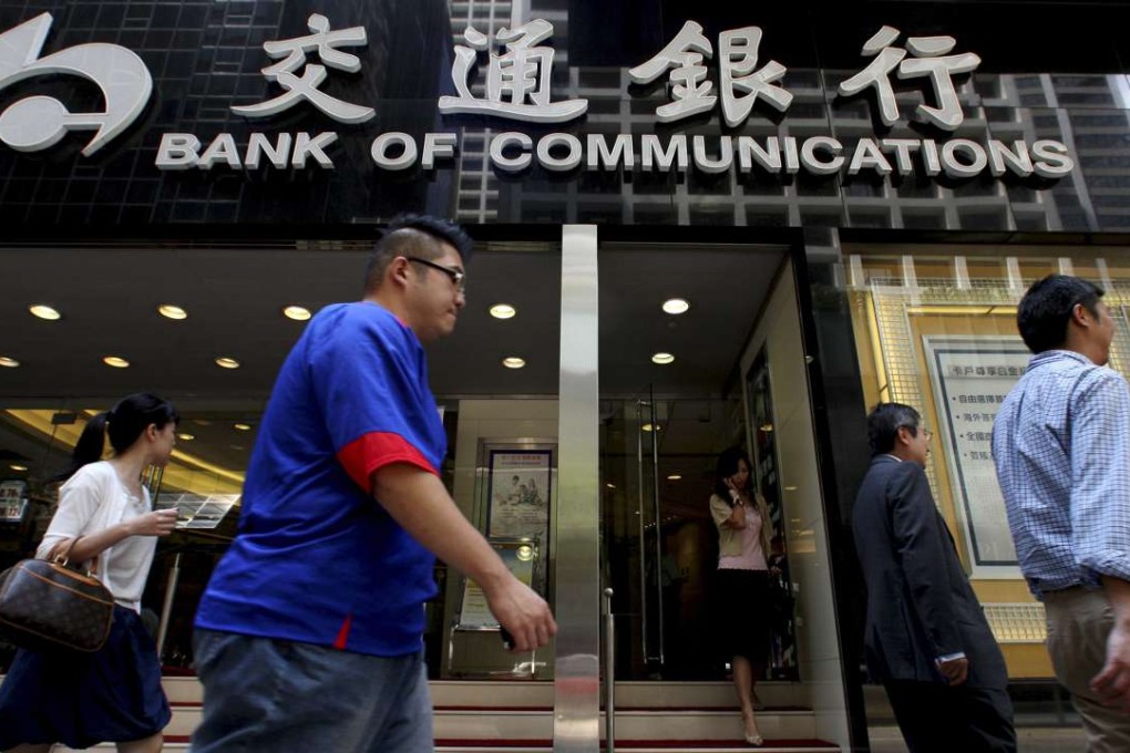 People walk past the Bank of Communications at its central branch in the financial district of Hong Kong in this August 19, 2009 file photo. REUTERS/Aaron Tam/Files