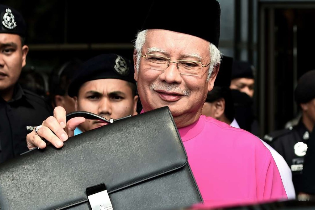 Malaysia's Prime Minister Najib Razak poses with his briefcase as he leaves to unveil the 2017 financial budget to Parliament House. Photo: AFP