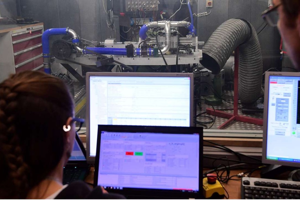Technicians work on a single-piston car engine invented by Shaul Yakobi. Photo: AFP
