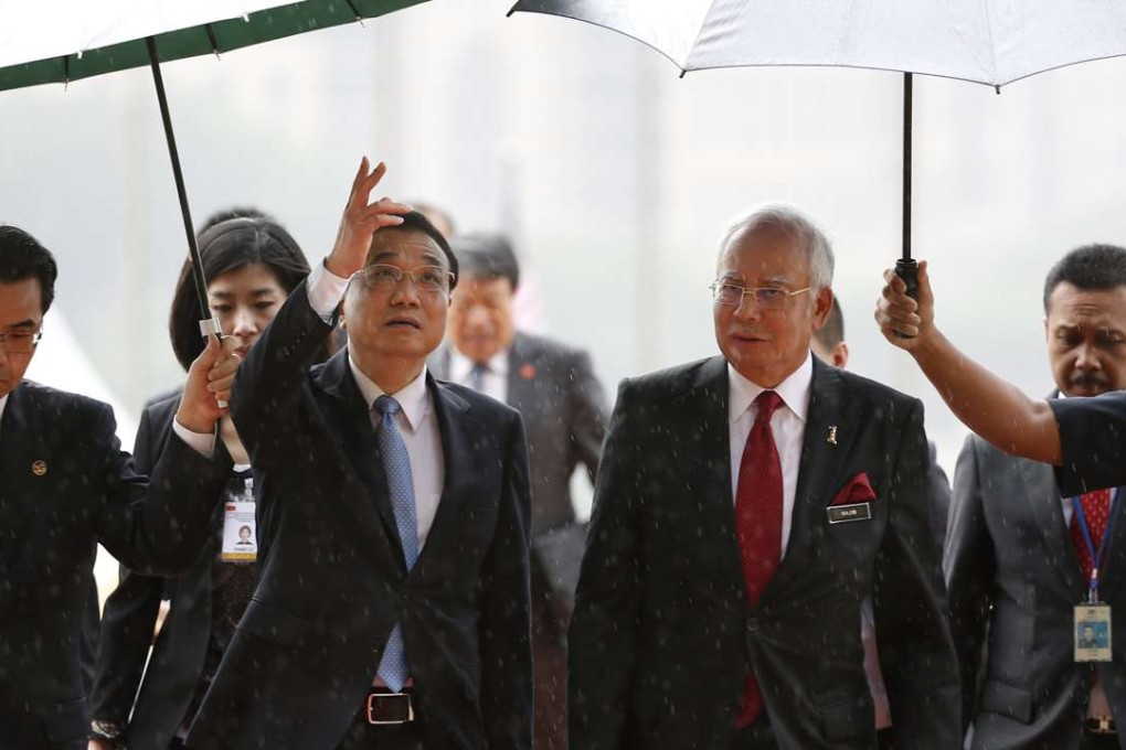 Chinese Premier Li Keqiang takes shelter from the rain with Malaysian Prime Minister Najib Razak after inspecting a guard of honor in Putrajaya, Malaysia in 2015. Photo: AP