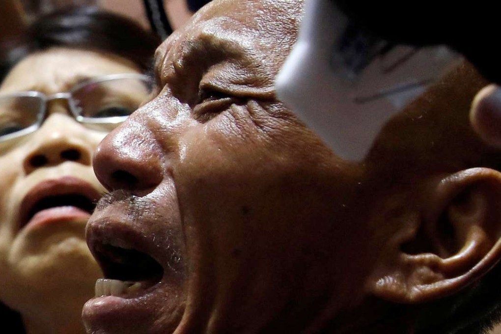 Shen Jui-chang cries beside with his wife (left) at Taiwan Taoyuan International Airport on October 26 after he was freed by Somali pirates after being held hostage for nearly five years. Photo: Reuters